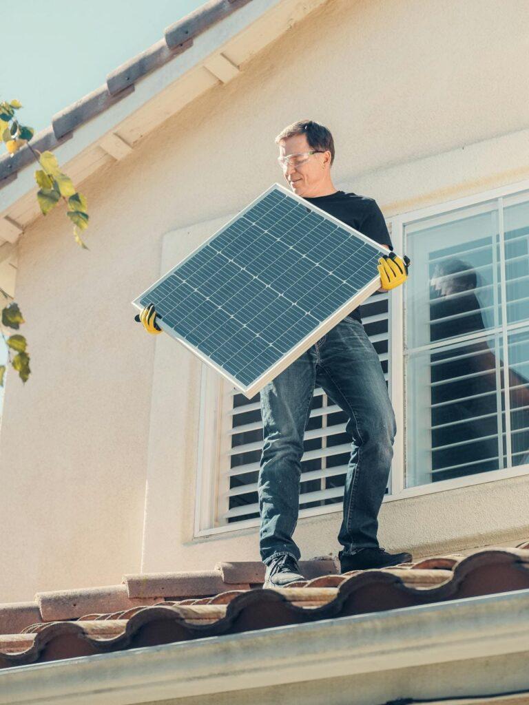 Ein Mann mit Solaranlage auf dem Dach