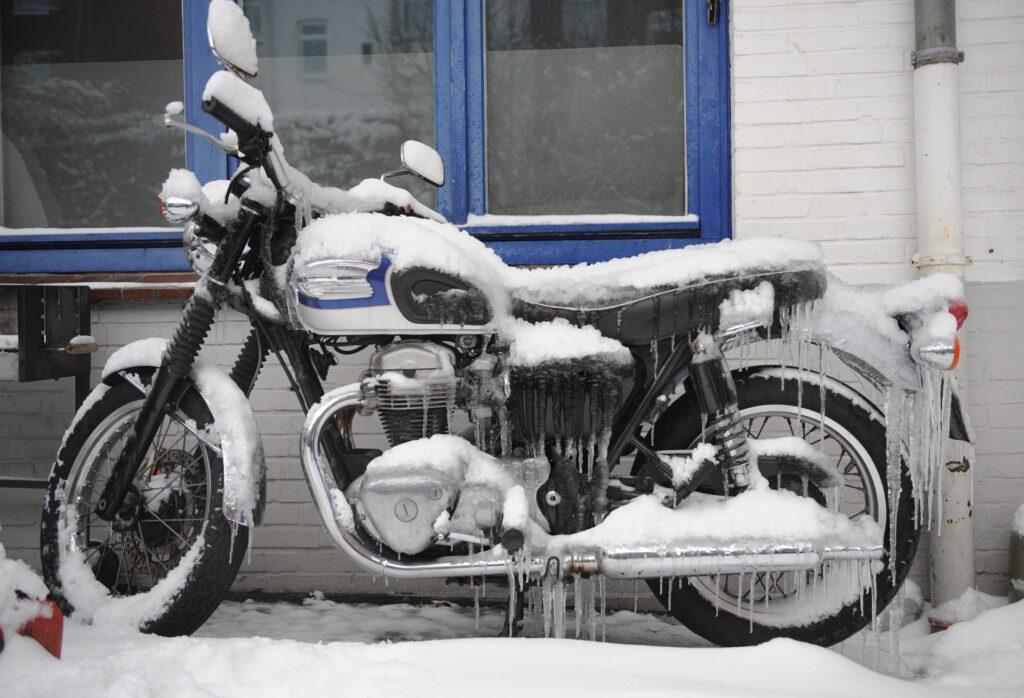 Verschneites Motorrad im Freien zeigt Winterrisiken | Motorrad Schutz